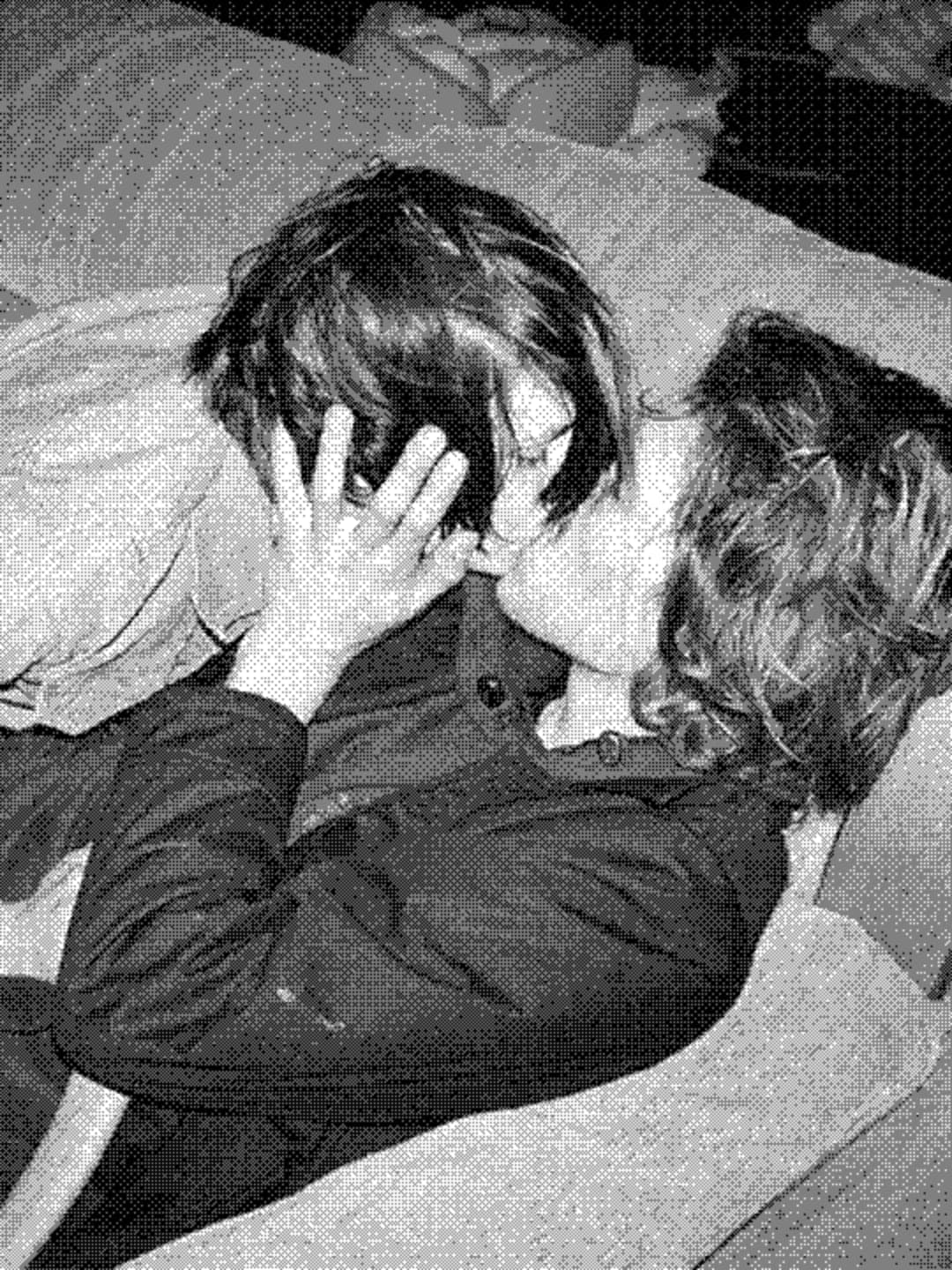 Two people kissing on a sofa